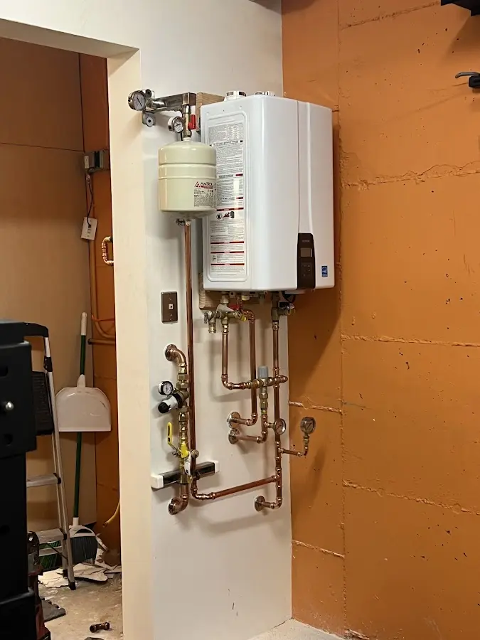 Plumbing technician inspecting water heater connections in East Nottingham
